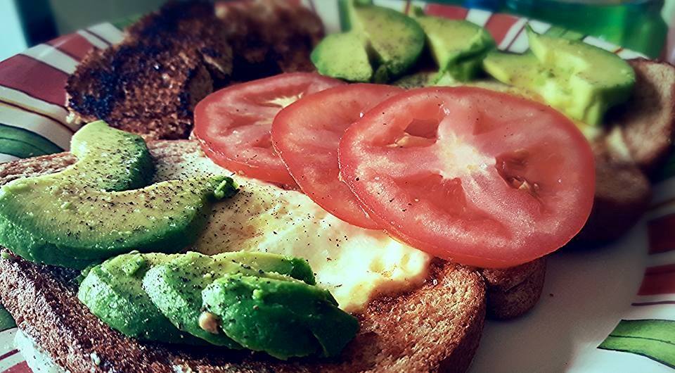 eggs in a basket with avocado and tomato